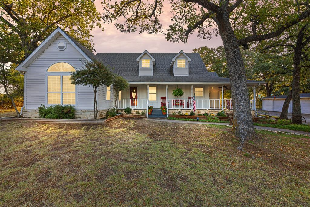 a front view of a house with a yard and trees