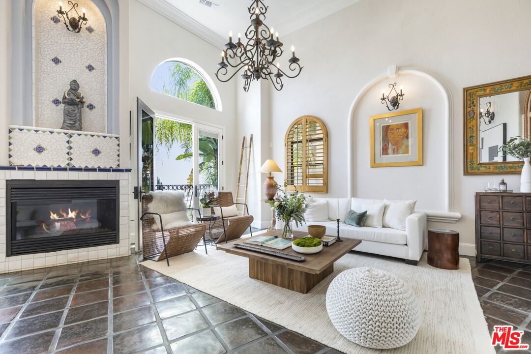 a living room with furniture a chandelier and a fireplace