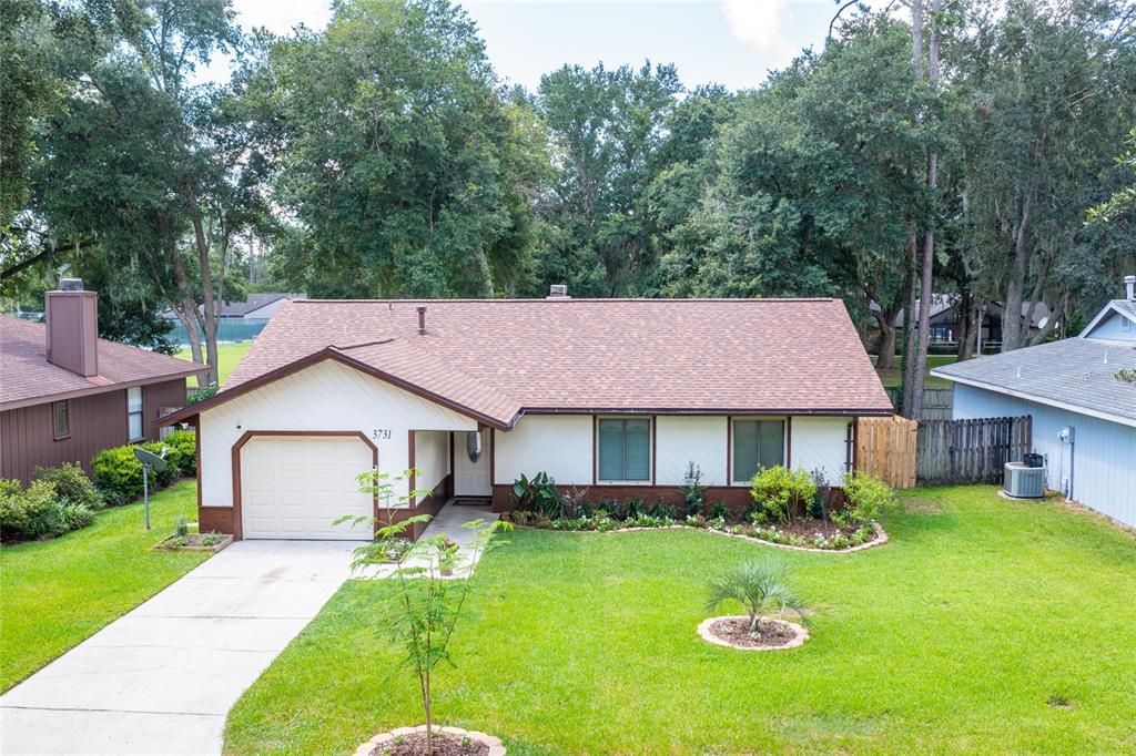 a front view of a house with a yard and trees