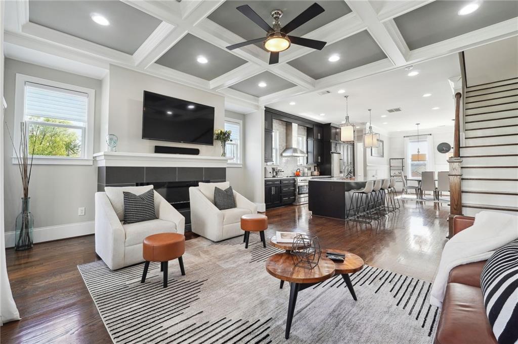 a living room with furniture a flat screen tv and kitchen view