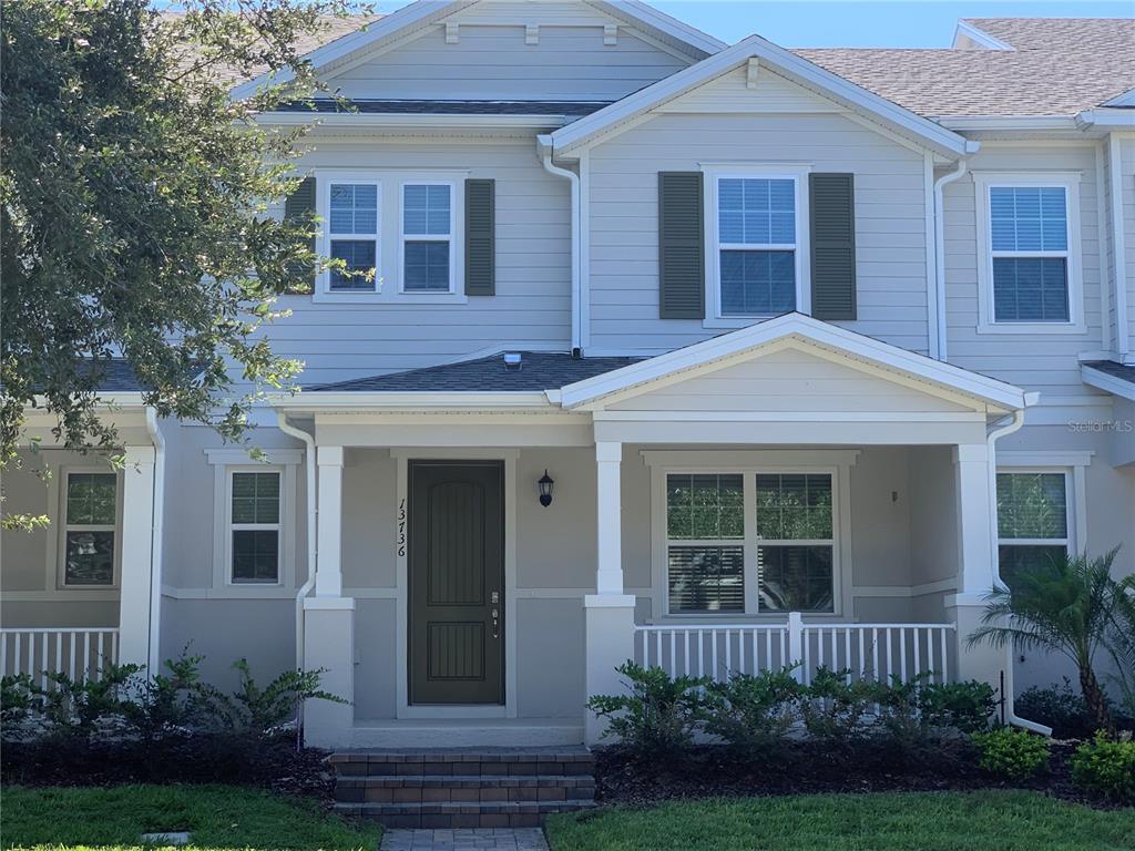 a front view of a house with a yard and plants