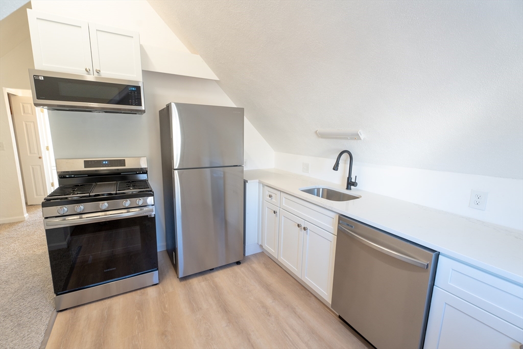 a kitchen with a sink stainless steel appliances and cabinets