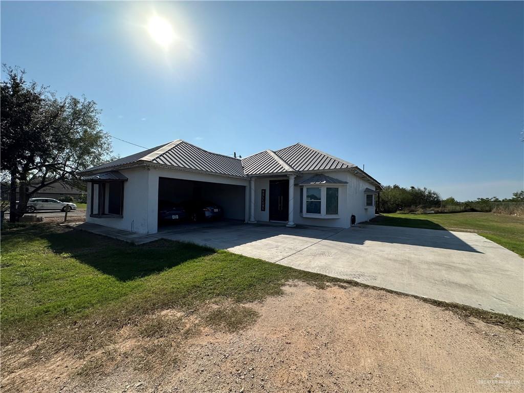 View of front of house with a garage and a front lawn