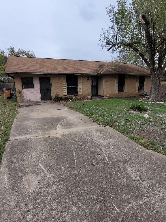 a view of a house with a yard and large tree