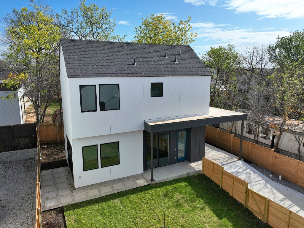 a front view of house with yard and trees in the background