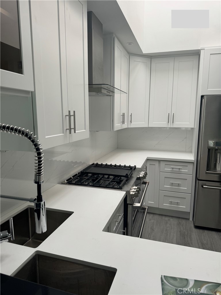 a kitchen with granite countertop a stove and a refrigerator