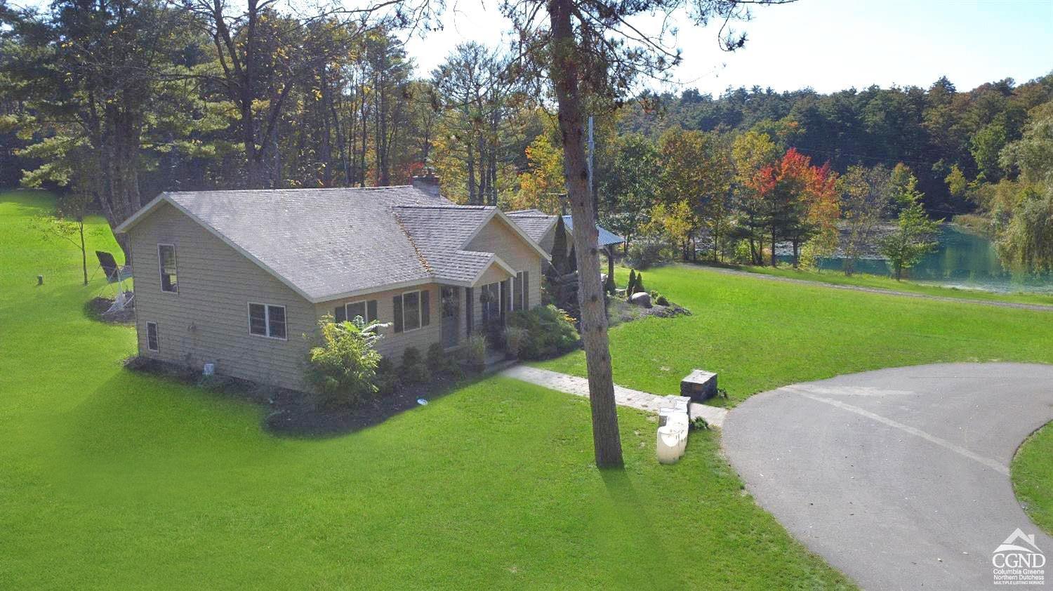 a view of a house with pool and a yard