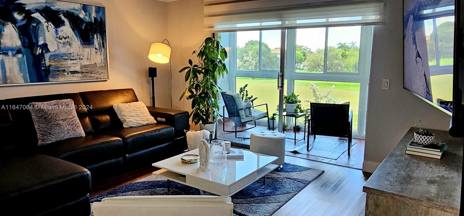 a living room with furniture and a floor to ceiling window