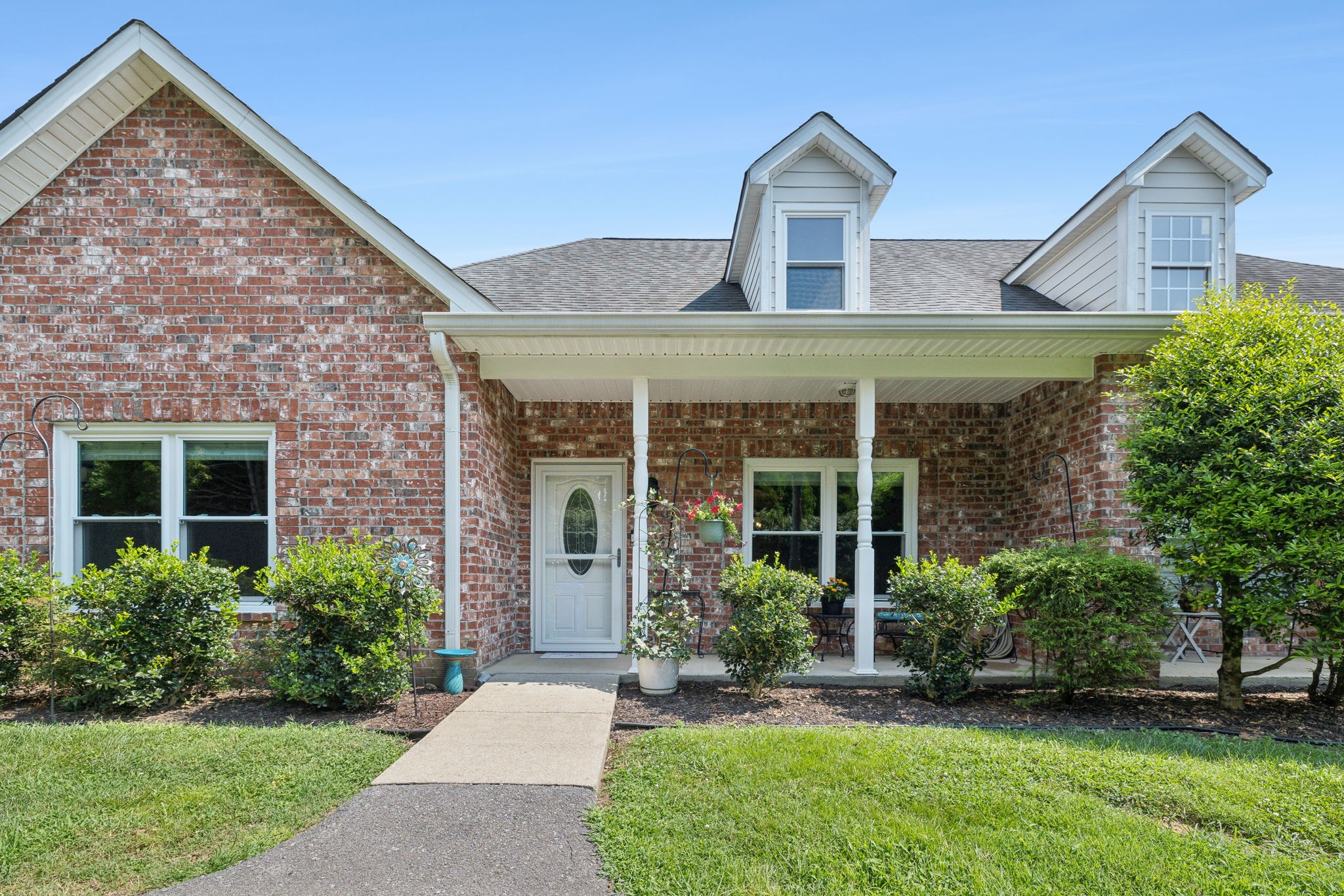 a front view of a house with a yard and potted plants