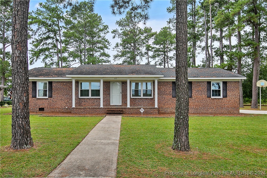 a front view of a house with a yard and trees