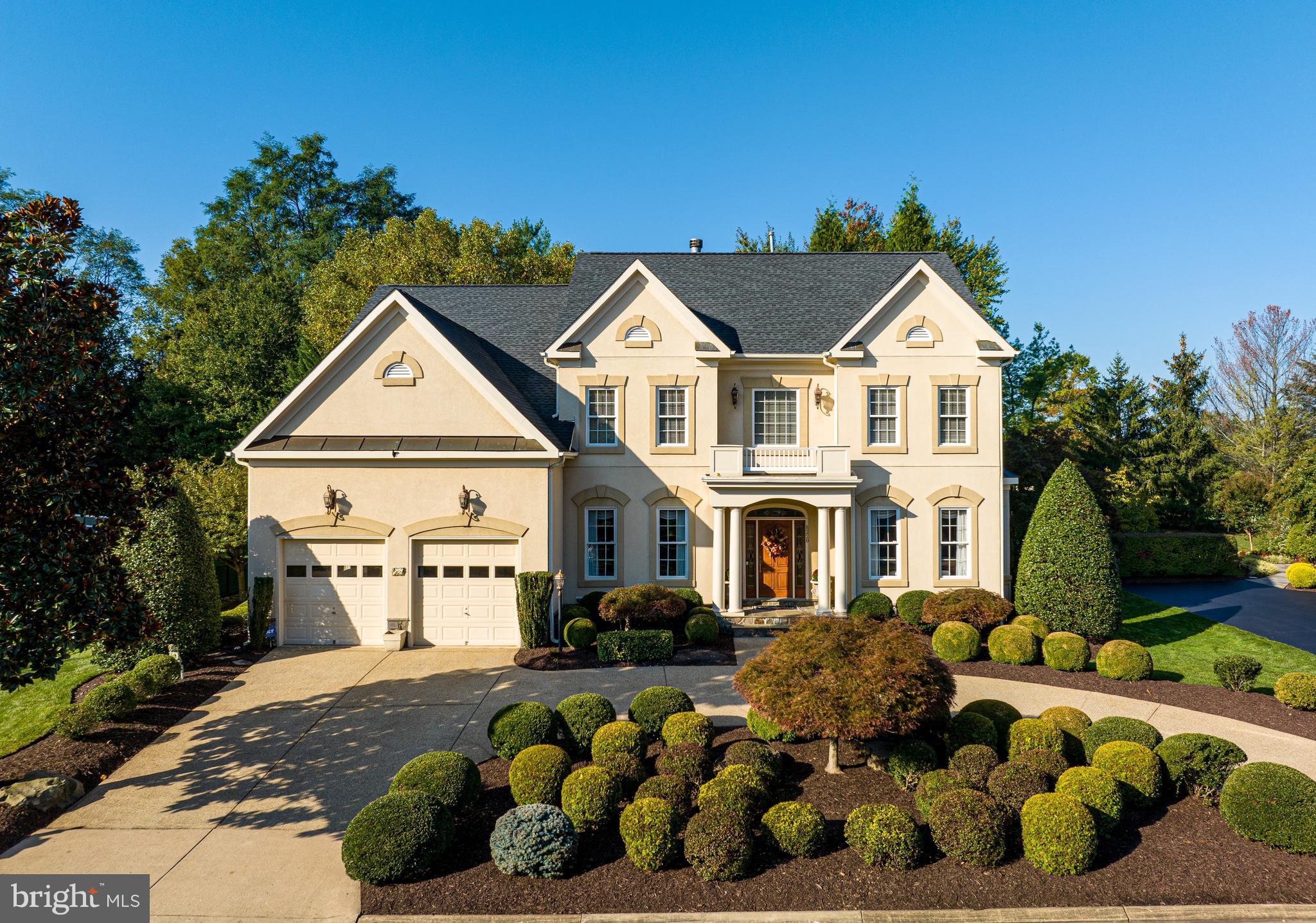 a front view of a house with a yard outdoor seating and covered with trees