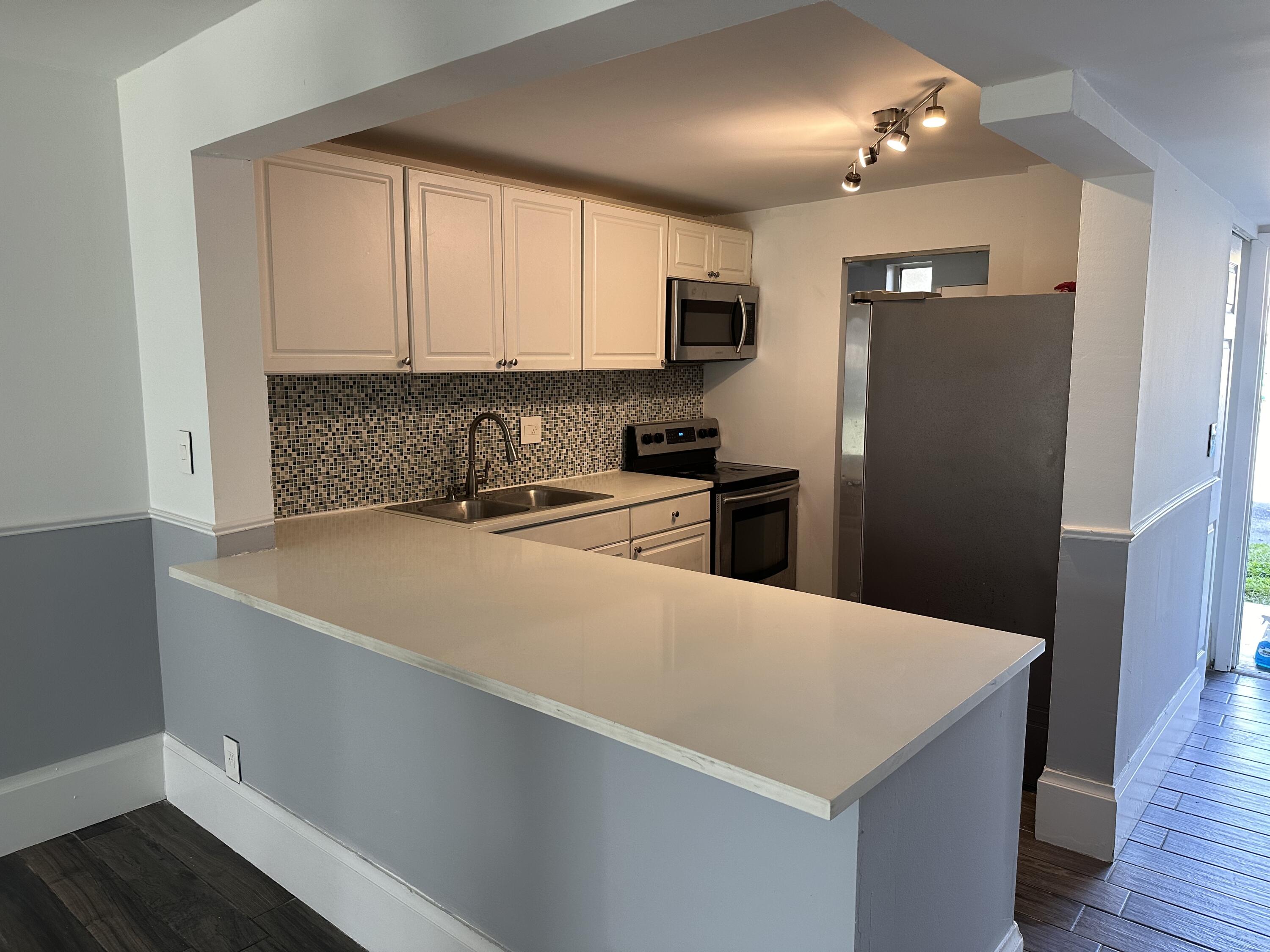 a kitchen with kitchen island a refrigerator sink and stove