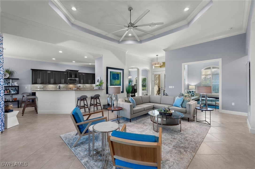 a living room with furniture kitchen view and a chandelier