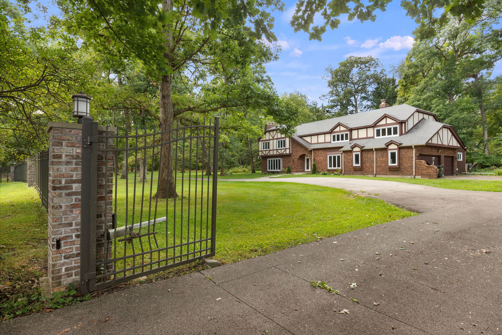 a front view of a house with garden and trees