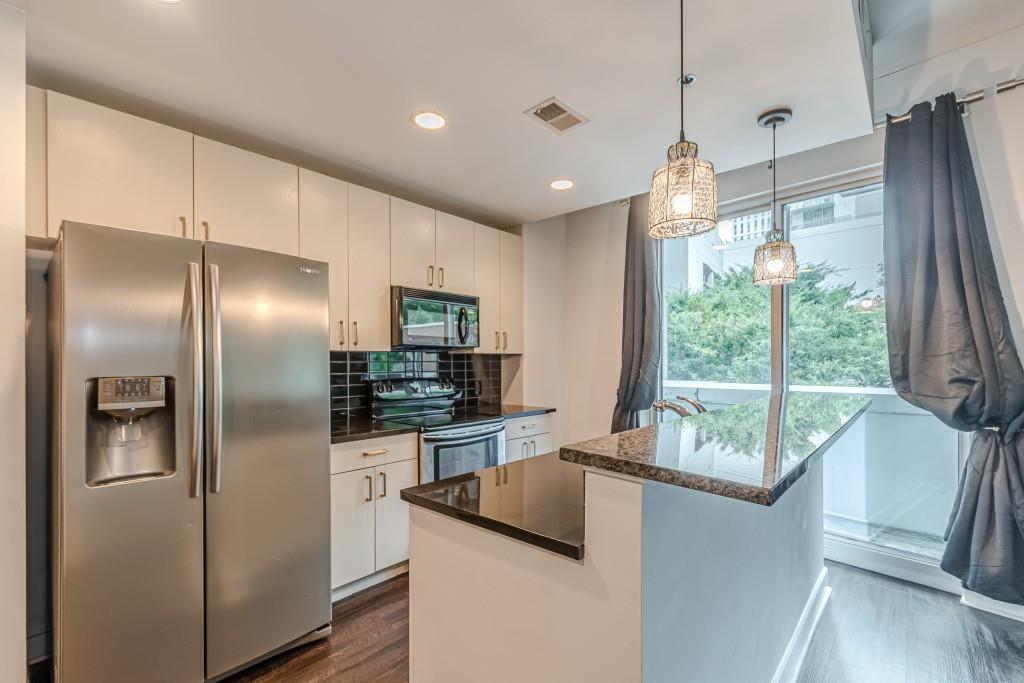 a kitchen with stainless steel appliances granite countertop a refrigerator and a sink