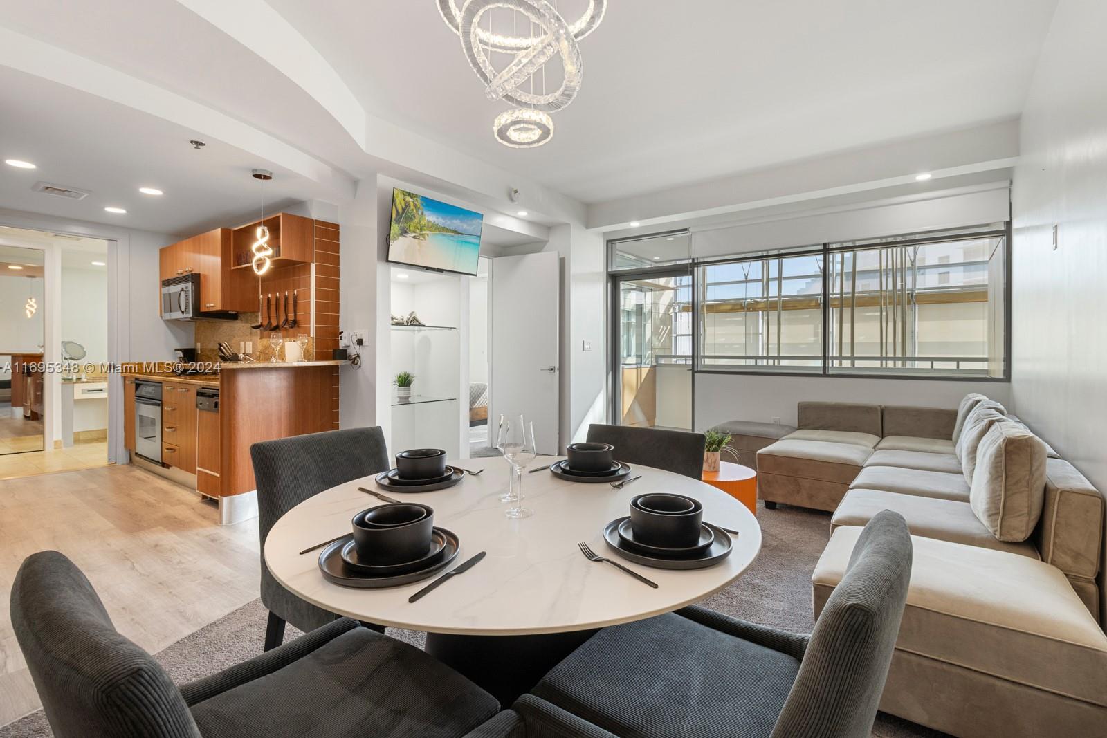 a dining room with furniture a large window and stainless steel appliances