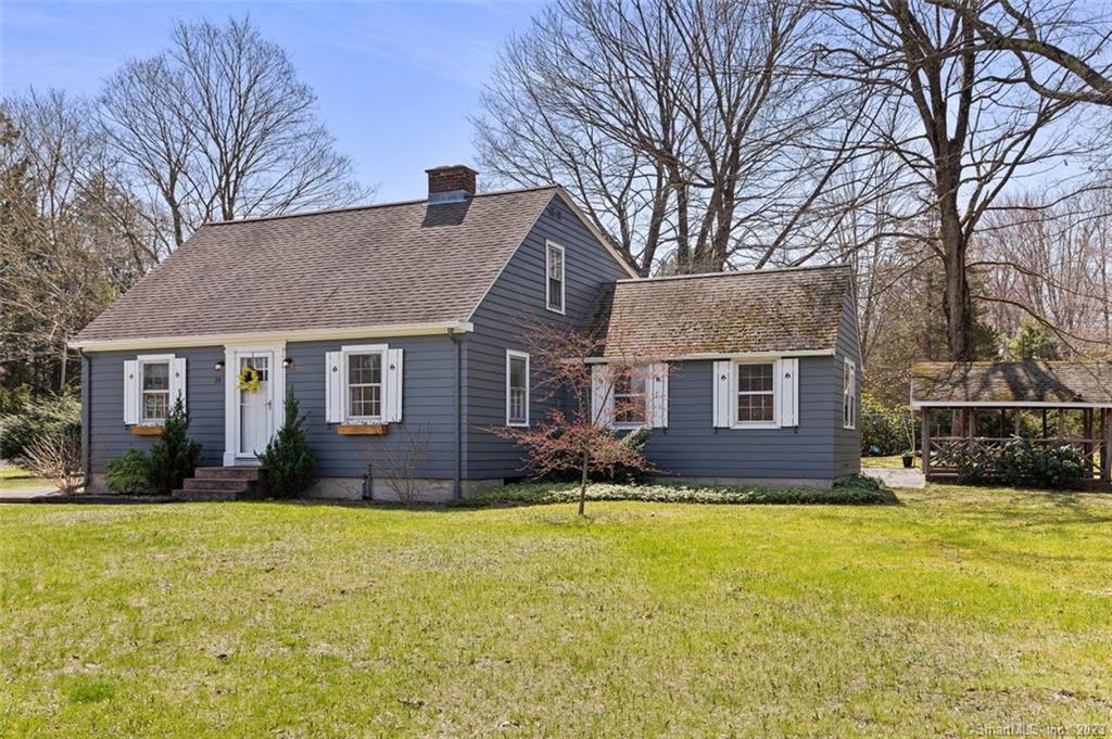 a front view of house with yard and trees around