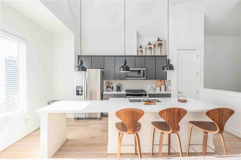 a kitchen with stainless steel appliances kitchen island granite countertop a table and chairs