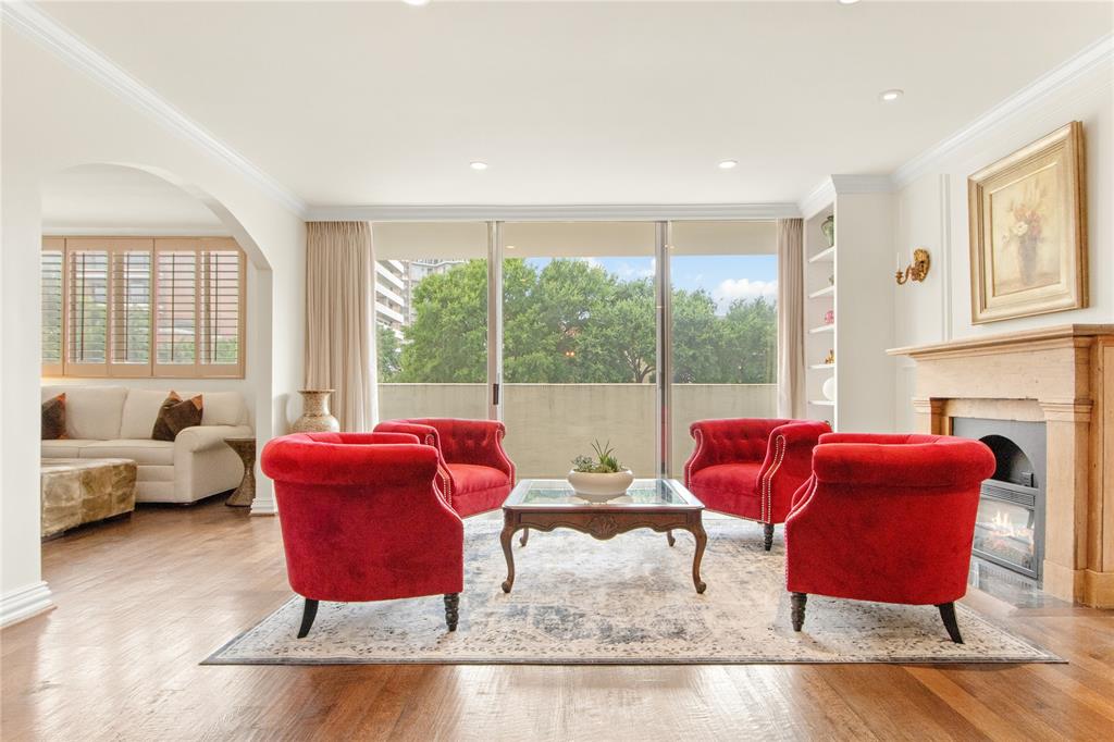 a living room with furniture a large window and a wooden floor