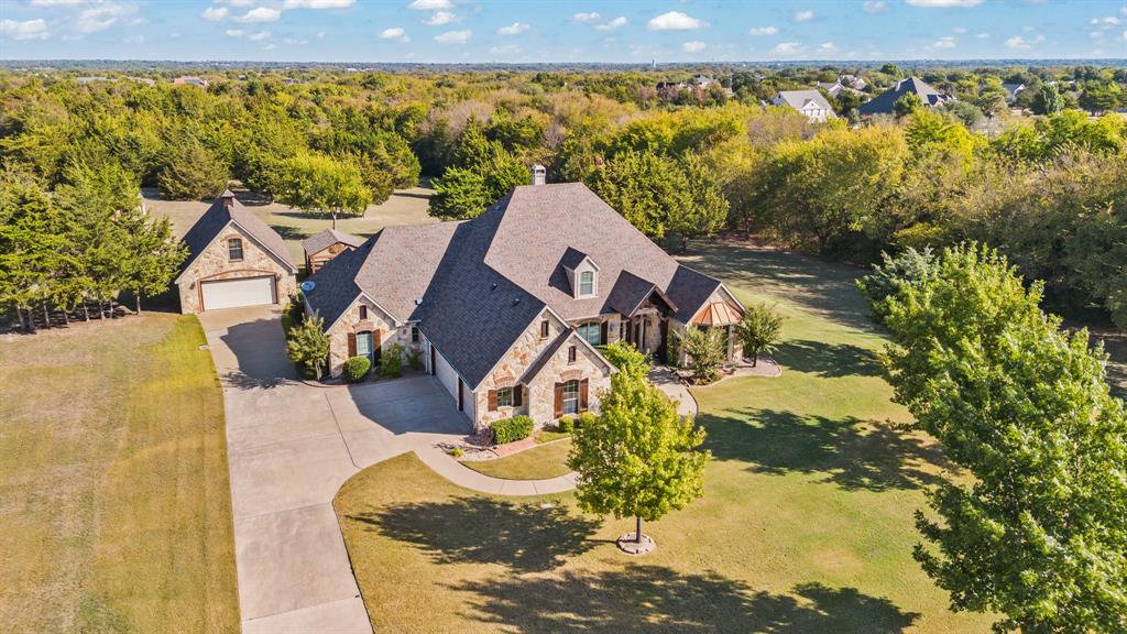 an aerial view of a house with a yard and ocean view