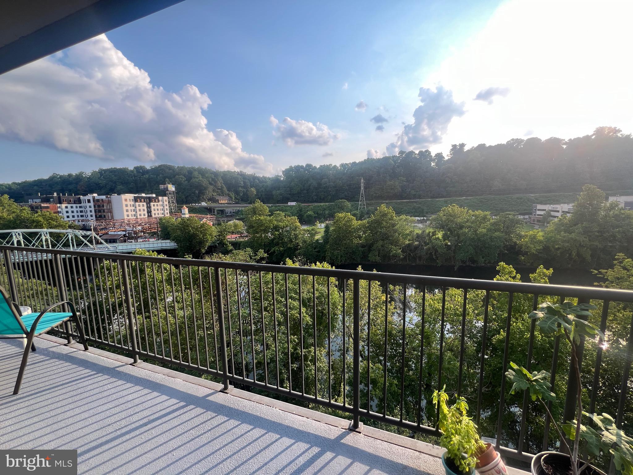 a view of a balcony with wooden floor & fence