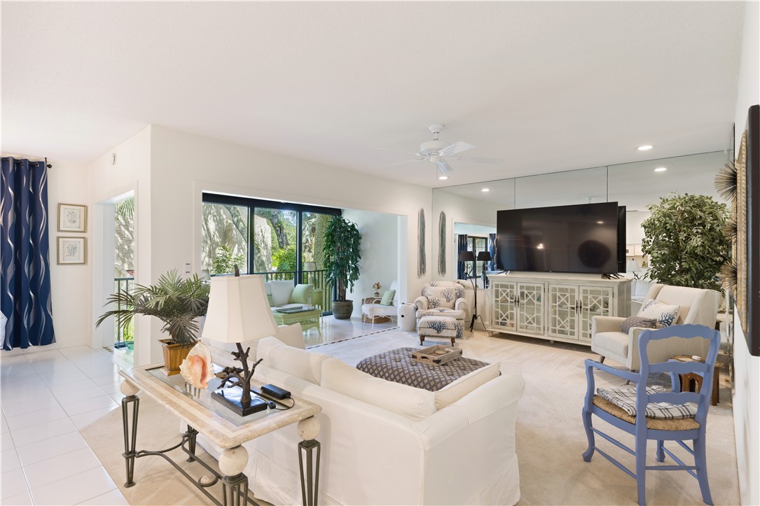 a living room with furniture a flat screen tv and a large window