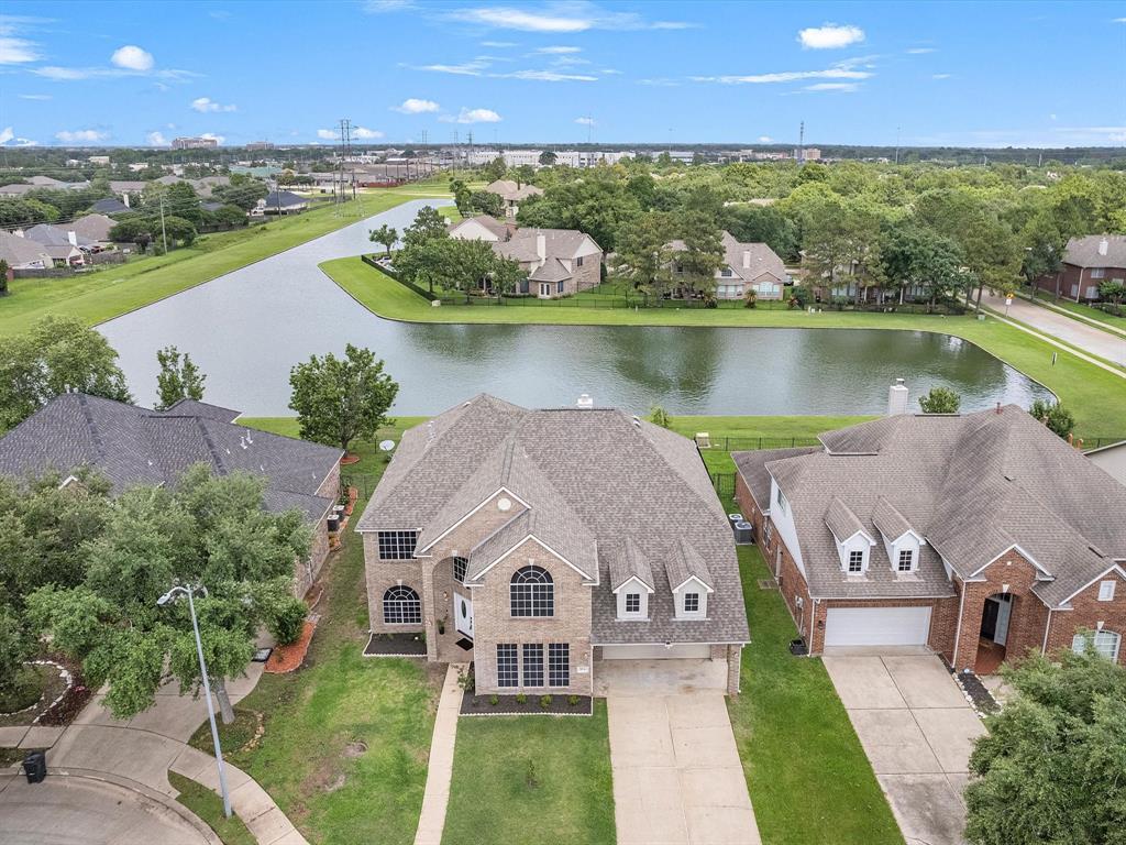 an aerial view of a house with a garden and lake view