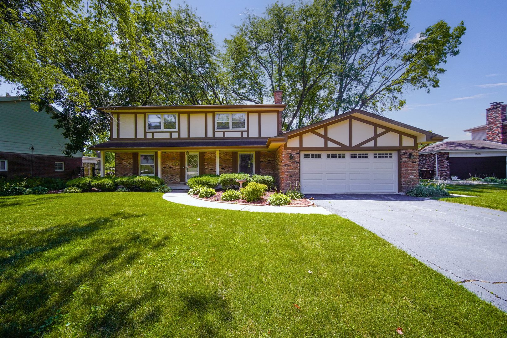 a front view of a house with a yard and trees