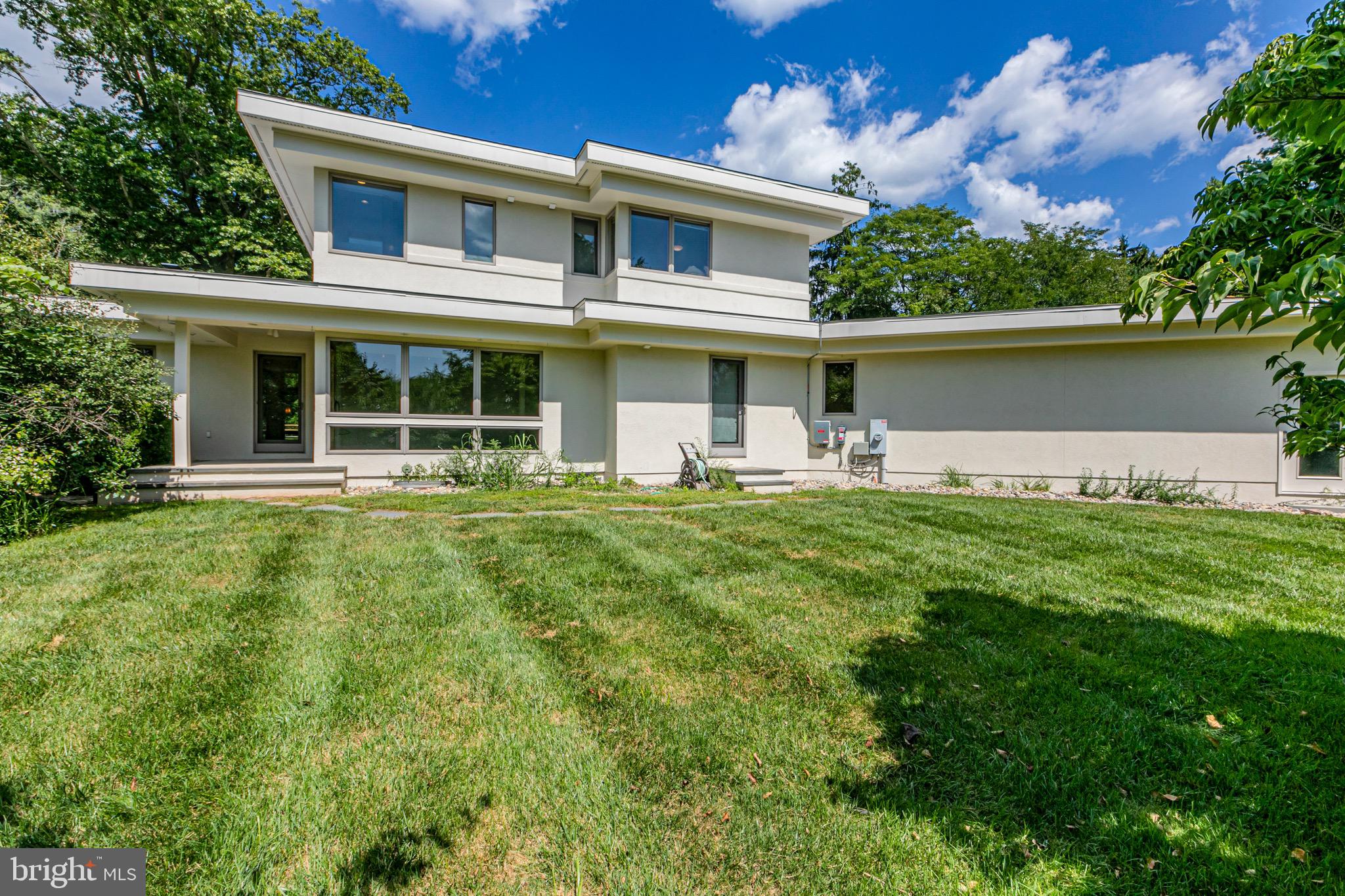 a front view of a house with yard and green space