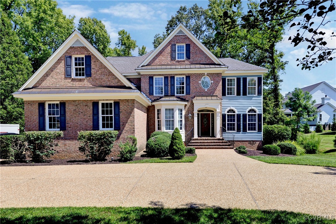 a front view of a house with yard and green space