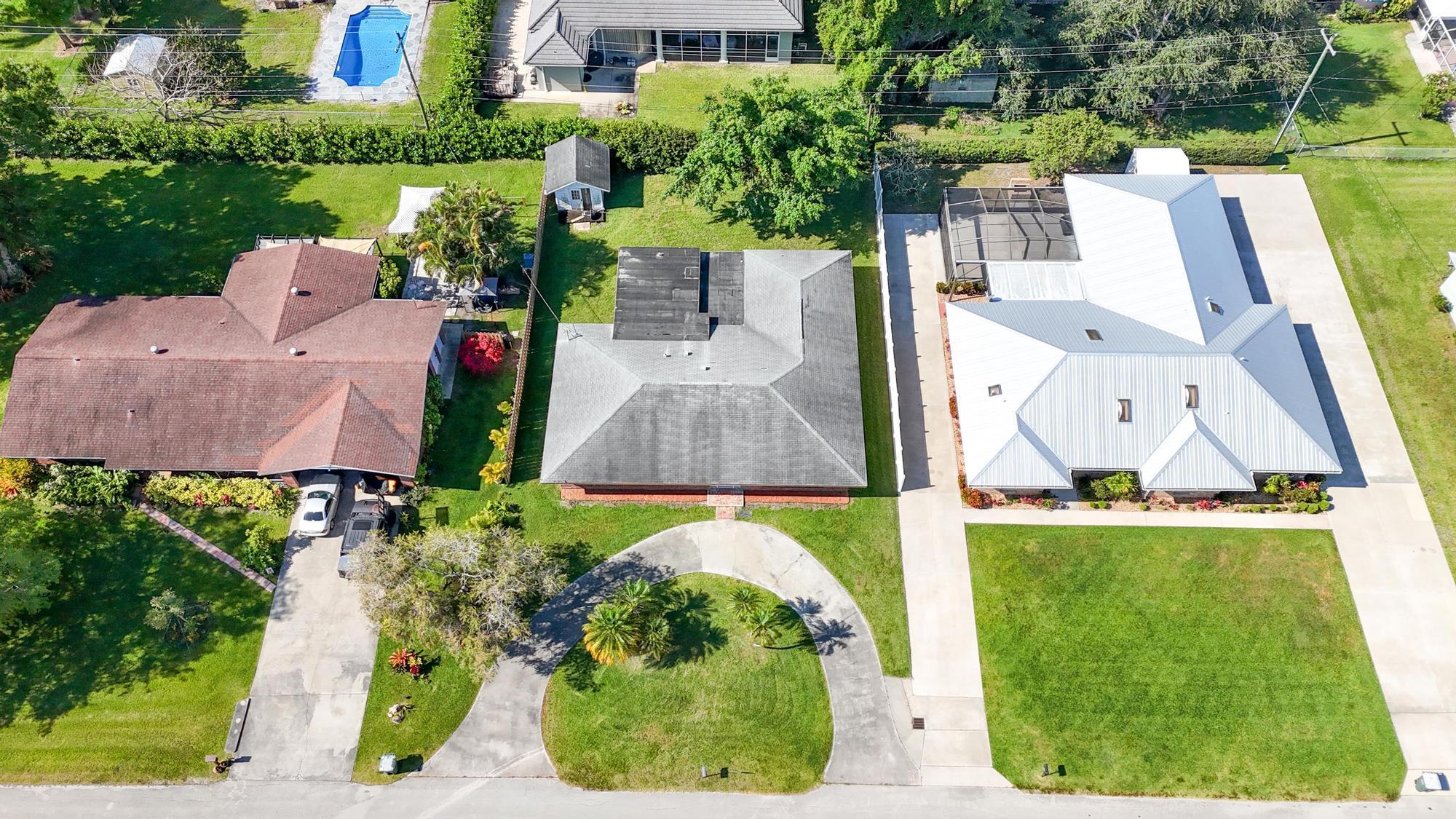 an aerial view of a house with a garden and swimming pool