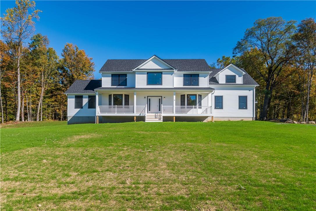 View of front of property with a porch and a front yard