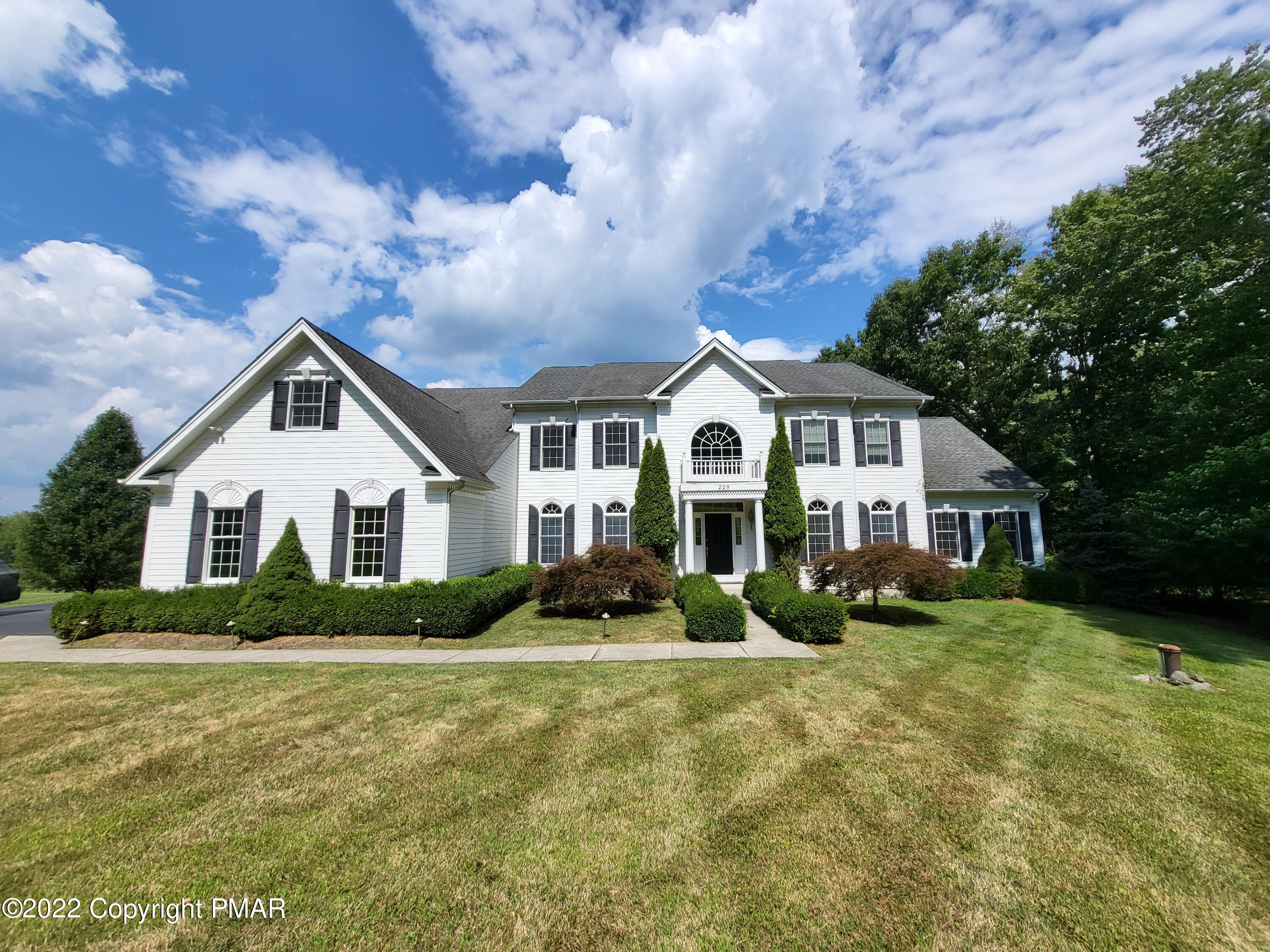 a front view of house with yard and green space