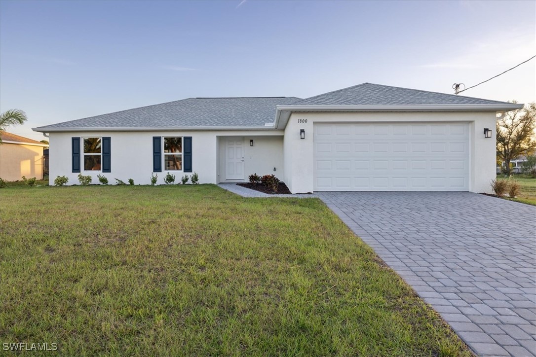 a front view of a house with a yard and garage