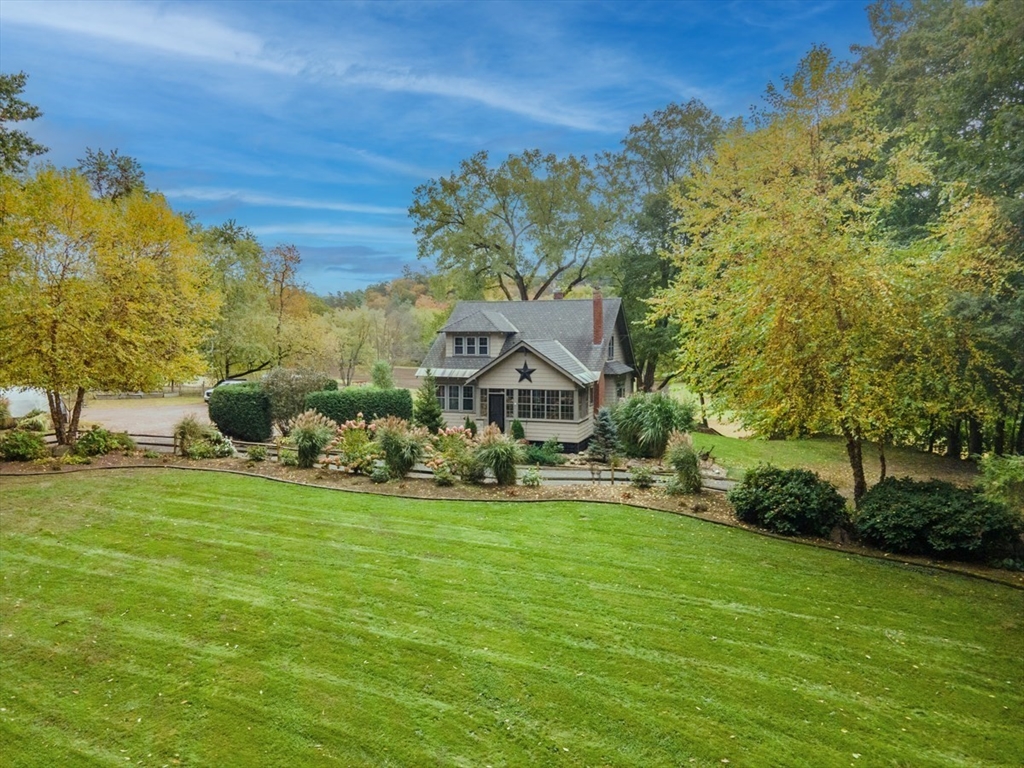 a aerial view of a house with a big yard and large trees