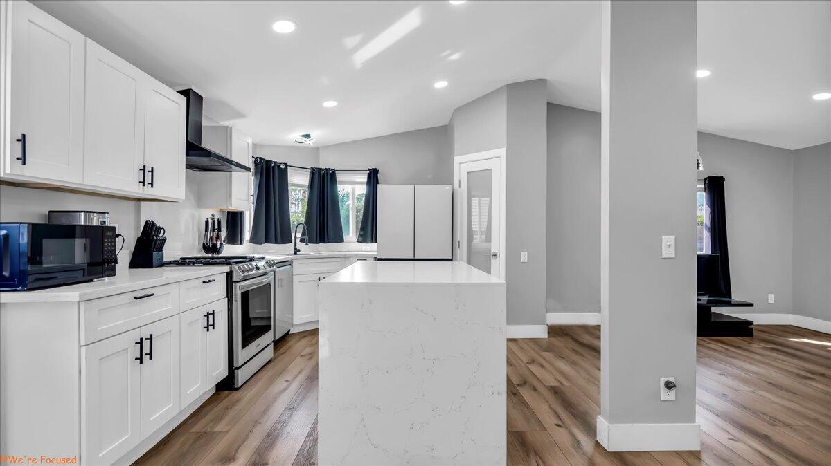 a kitchen with white cabinets and stainless steel appliances