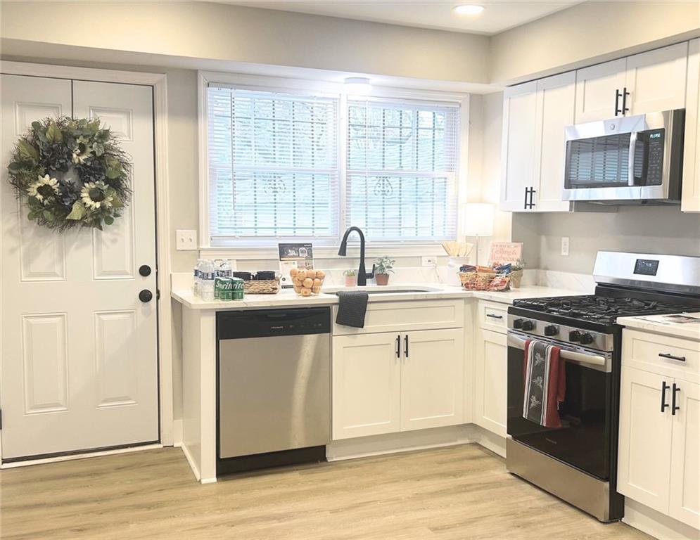 a kitchen with stainless steel appliances granite countertop a stove a sink and a microwave