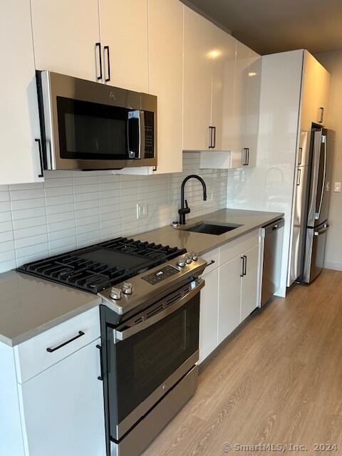 a kitchen with stainless steel appliances a sink a stove and microwave