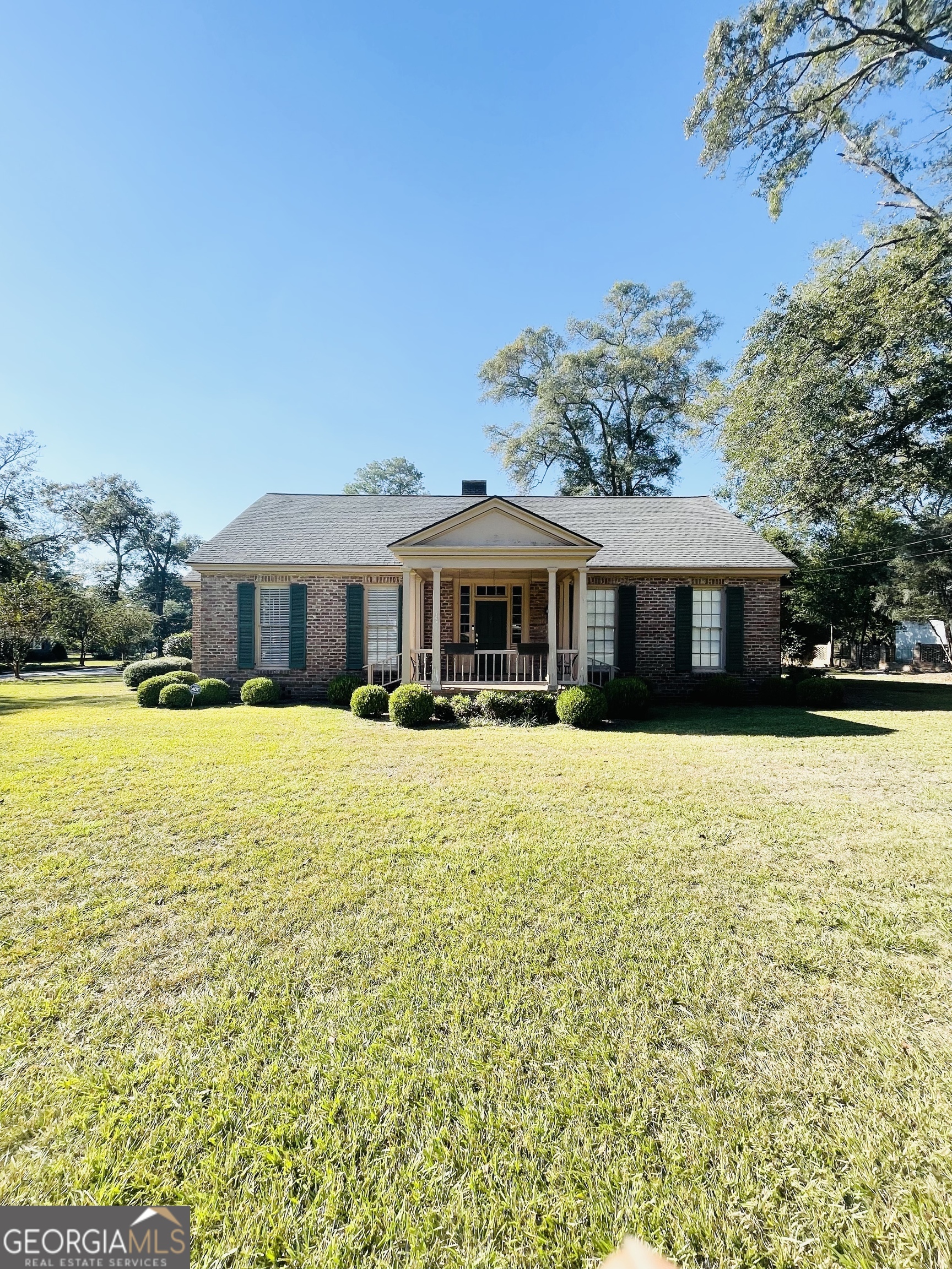 a front view of house with a garden and swimming pool