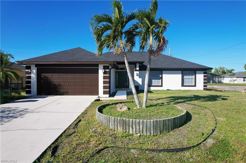 View of front of home featuring a front lawn and a garage