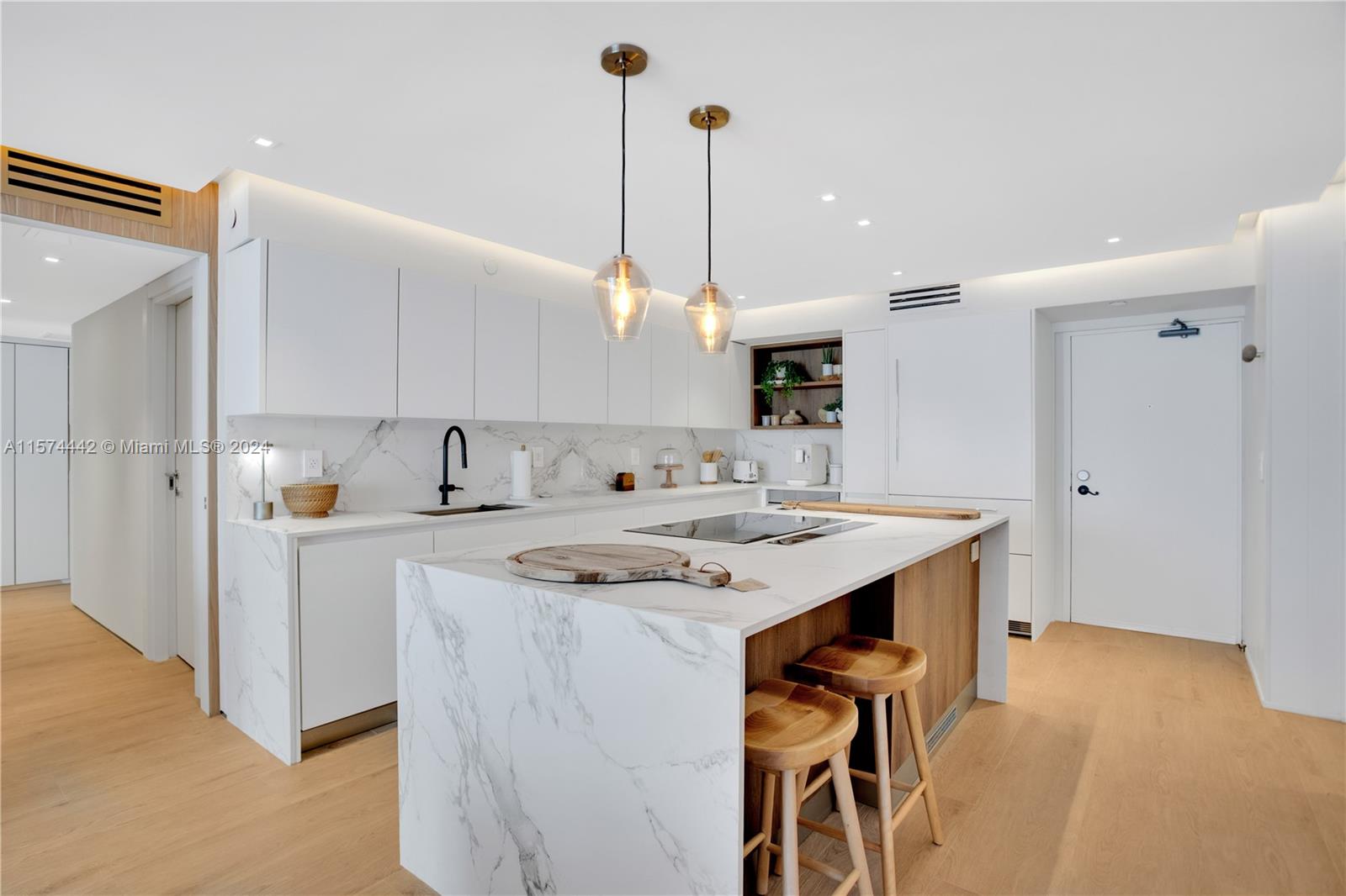 a kitchen with a sink a stove a refrigerator and white cabinets