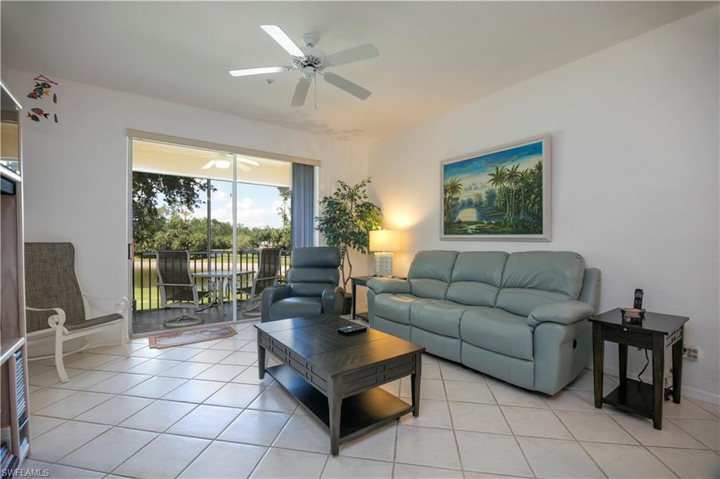 a living room with furniture a floor to ceiling window and a flat screen tv