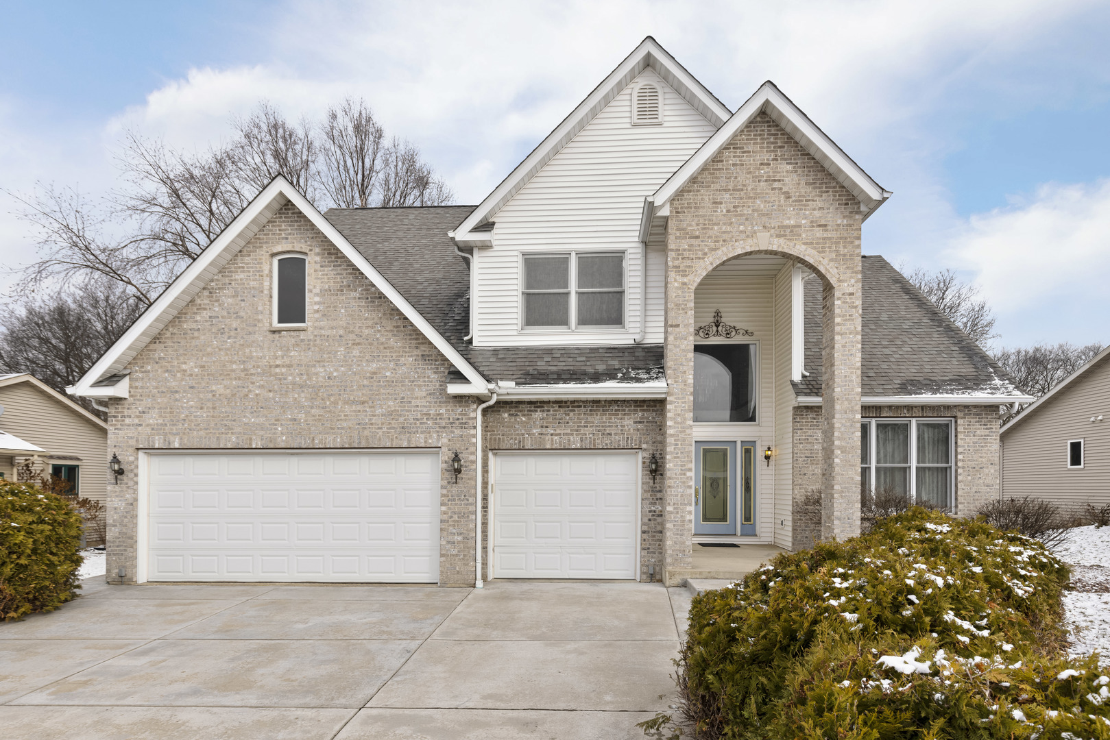 a view of house with garage and large window