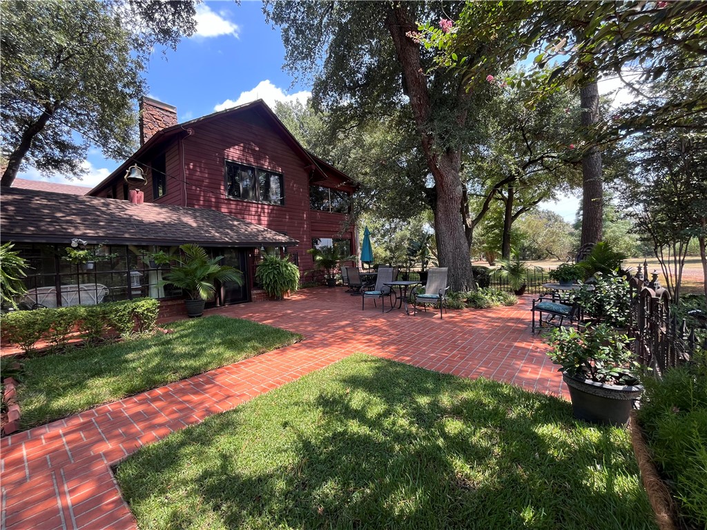 a view of a big yard with plants and large trees