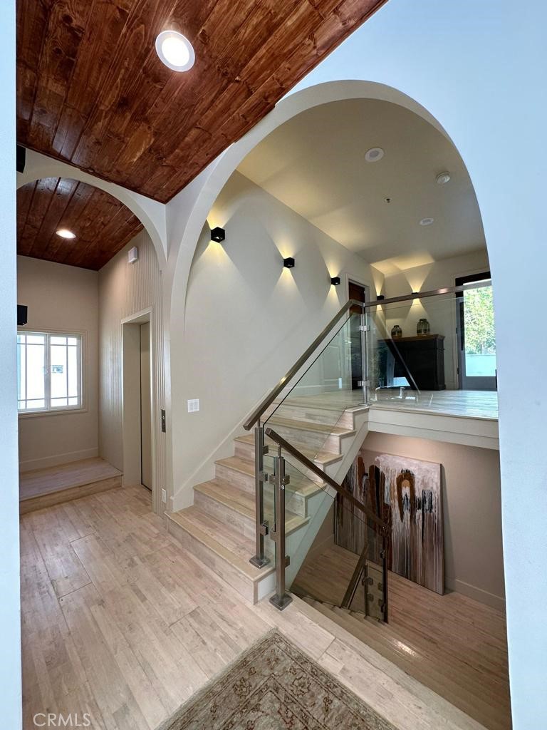 a view of a hallway with wooden floor and stairs