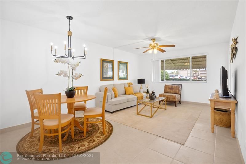 a living room with furniture a chandelier and a flat screen tv