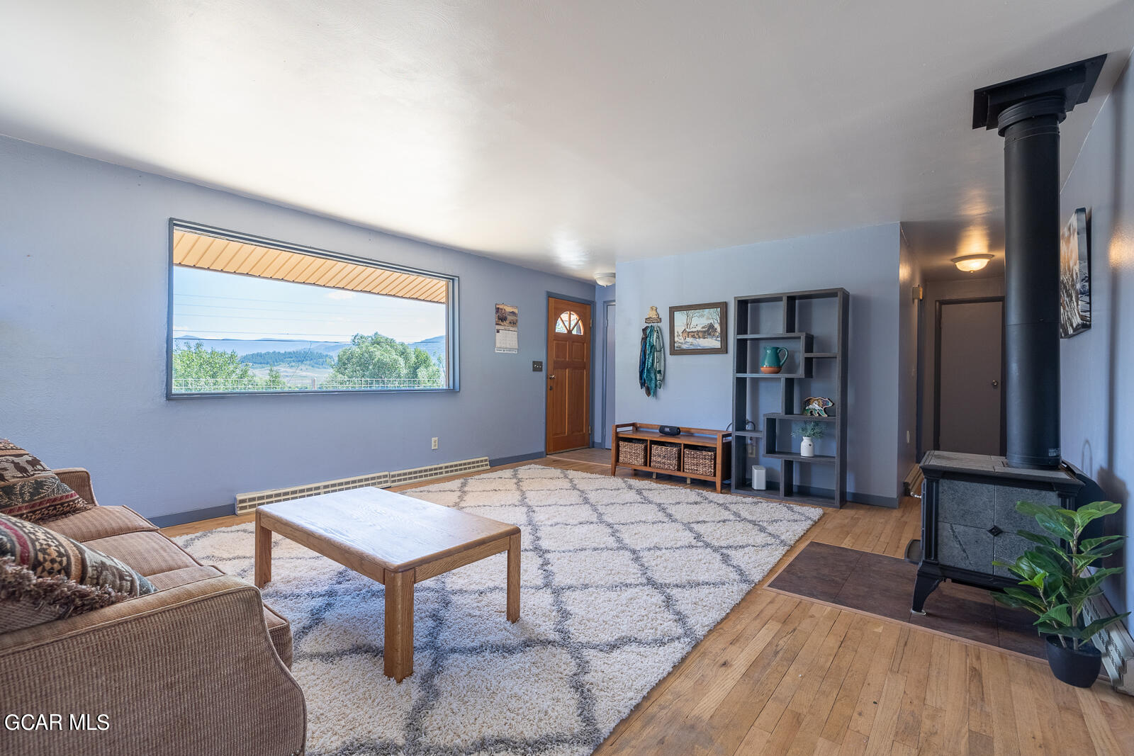 a living room with furniture a rug and a large window