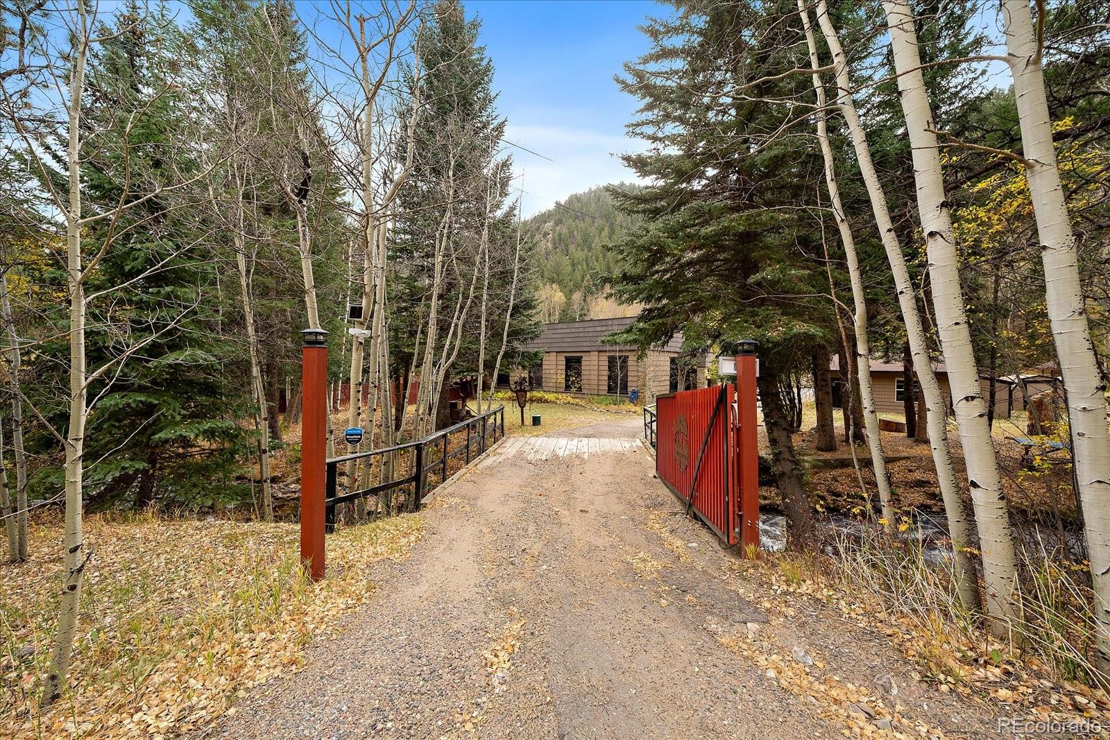 a view of tall trees with wooden fence