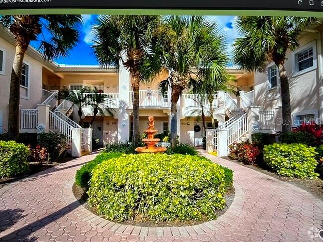 a view of a house with a small yard plants and palm trees