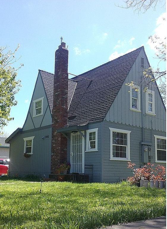 a front view of a house with a garden and plants